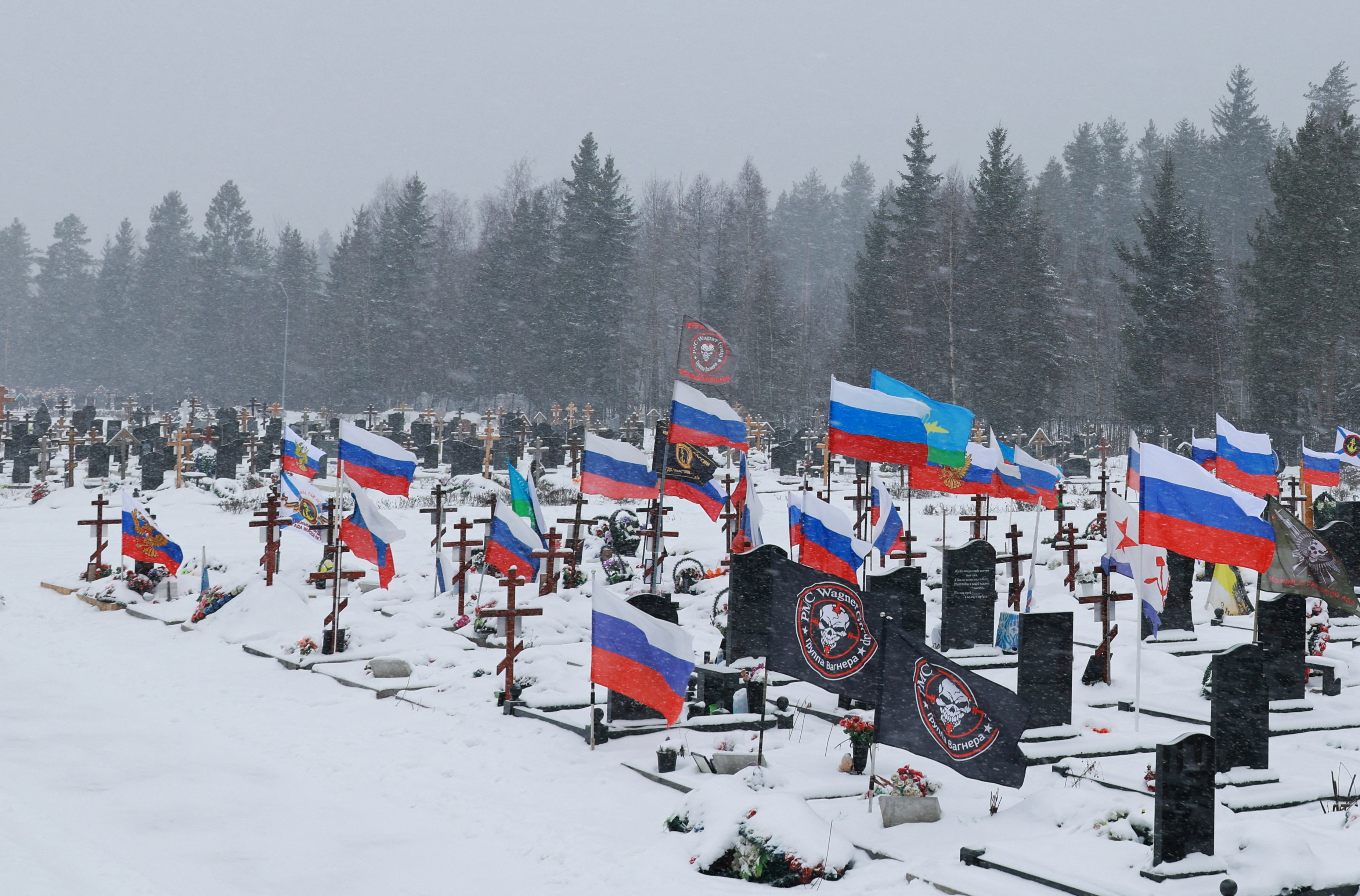 Flags fly over the graves of Russian soldiers at a cemetery in Saint Petersburg