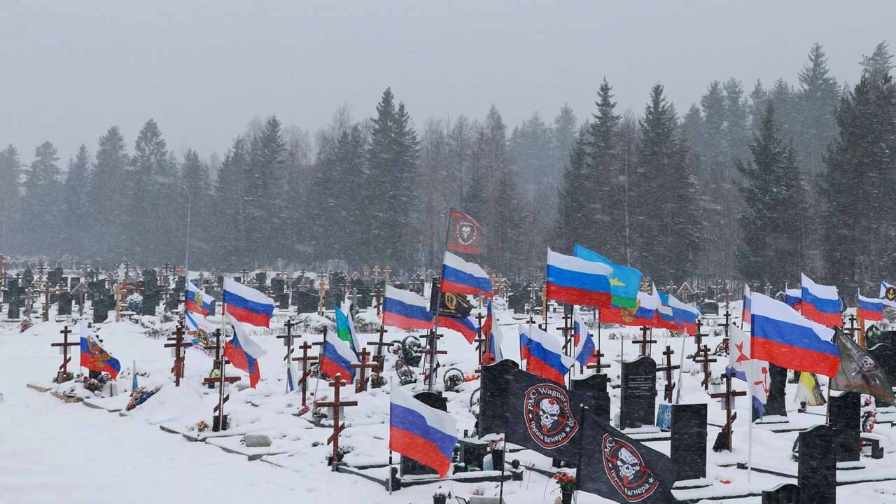 Flags fly over the graves of Russian soldiers at a cemetery in Saint Petersburg