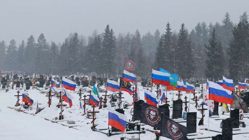 Flags fly over the graves of Russian soldiers at a cemetery in Saint Petersburg