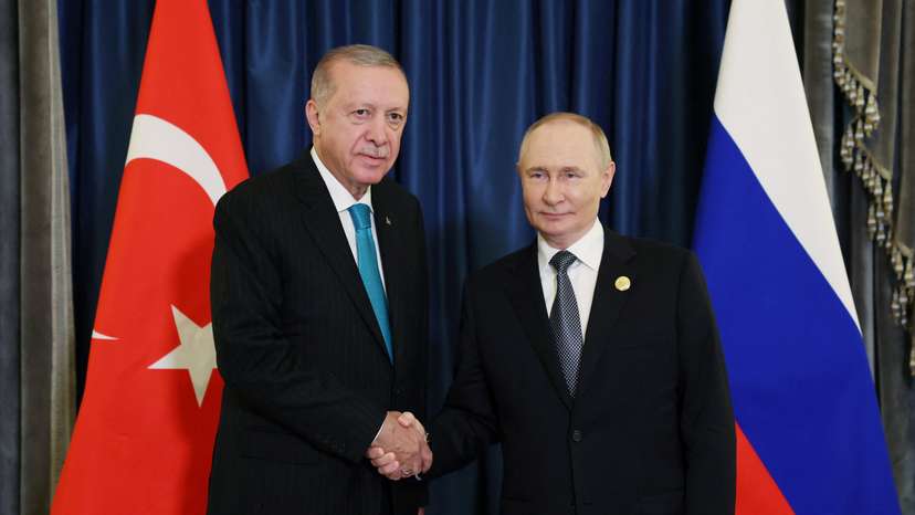 Turkish President Erdogan shakes hands with Russia's President Putin during a meeting in Tianjin
