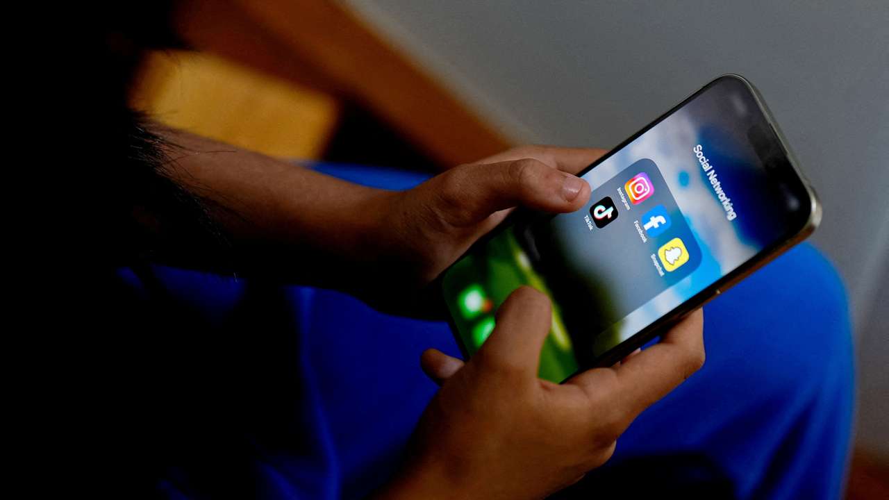 FILE PHOTO: High school student poses with her mobile showing her social media applications in Melbourne