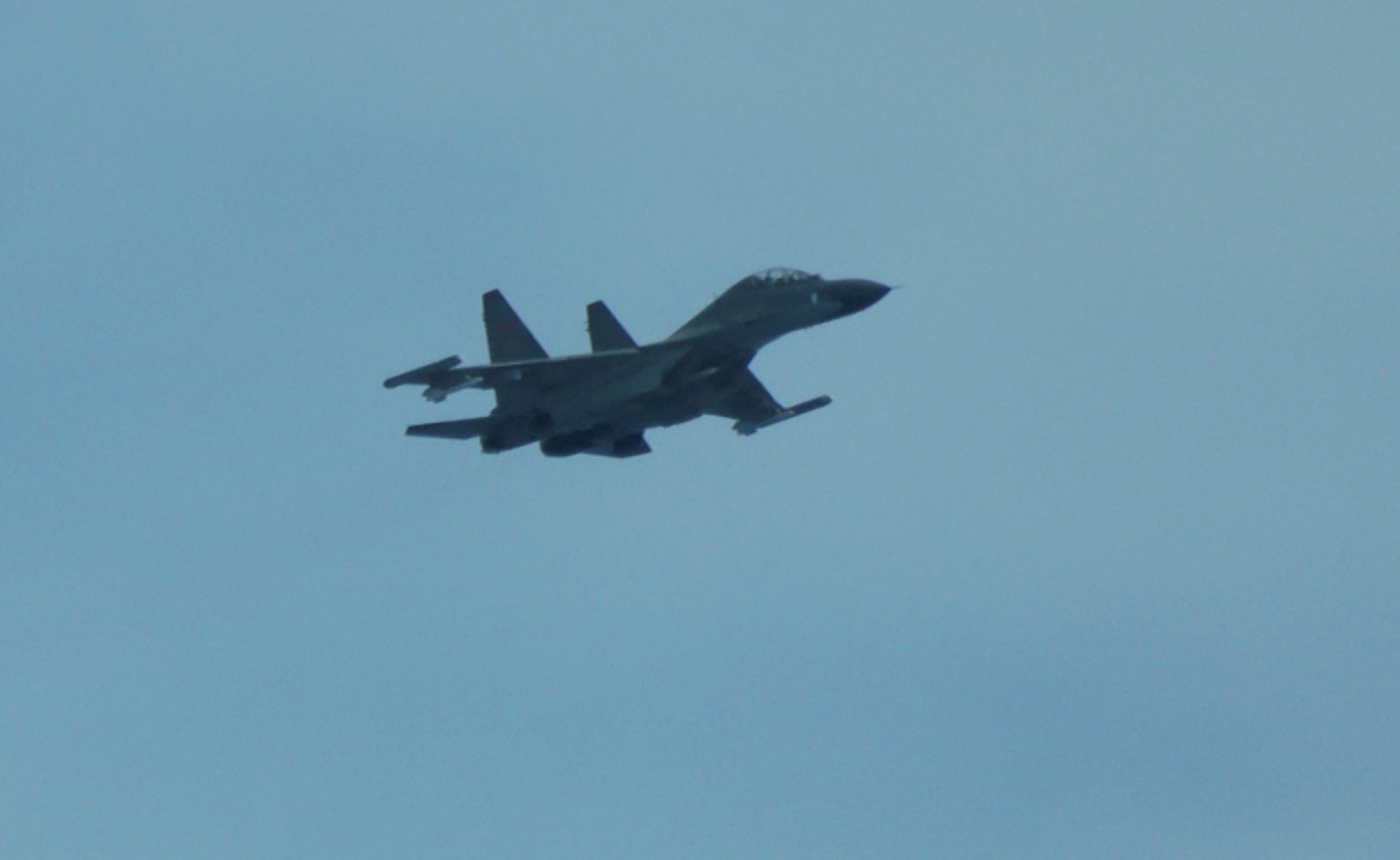 An aerial view of a Chinese fighter jet flying close to a Philippine Coast Guard aircraft carrying journalists, over the disputed Scarborough Shoal