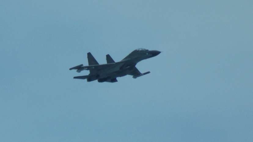 An aerial view of a Chinese fighter jet flying close to a Philippine Coast Guard aircraft carrying journalists, over the disputed Scarborough Shoal