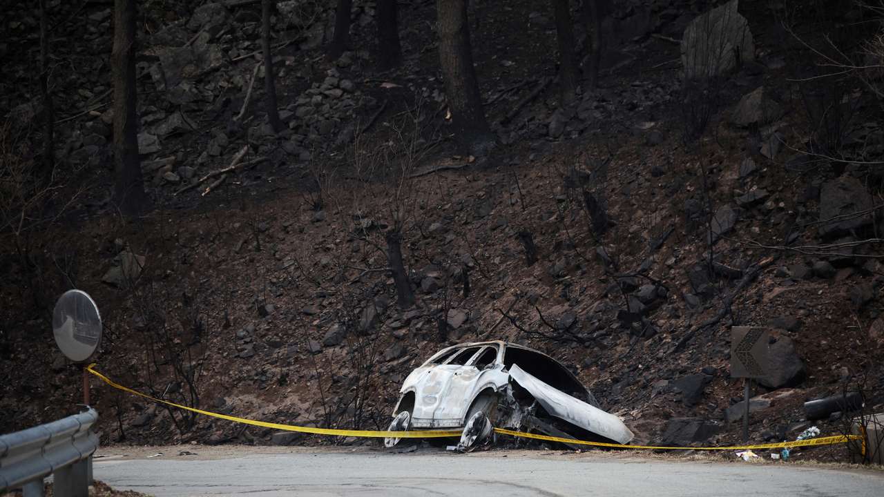 A burnt vehicle, in which a village leader Kwon and his wife were found dead while they were on their way back to their village to rescue other people during a wildfire, lies on the side of a road in Yeongyang