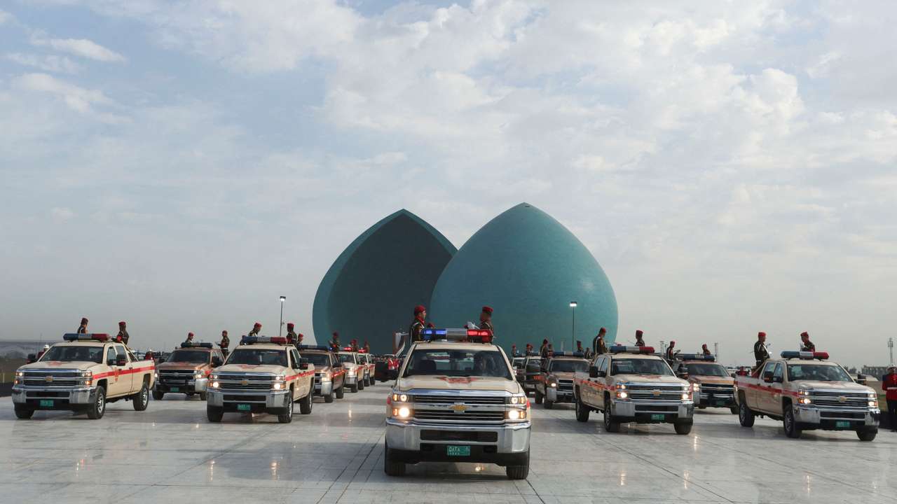 FILE PHOTO: Military vehicles belonging to the Iraqi security forces carry body remains of people from the minority Yazidi during a funeral ceremony in Baghdad