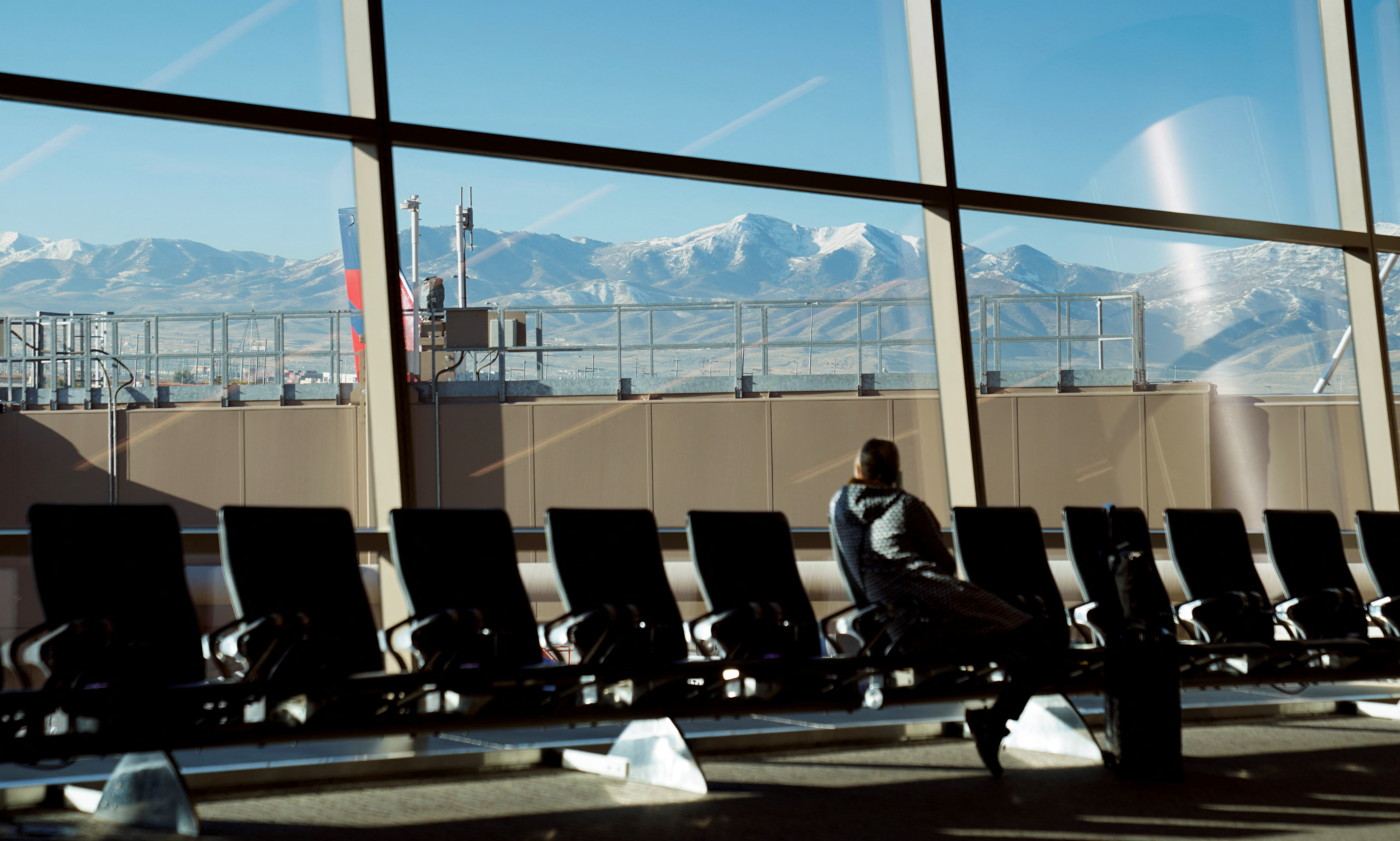 With the Wasatch Mountains in the background, a passenger waits at Salt Lake City International Airport in Utah