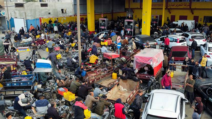 Palestinians wait to fill their cars with fuel, in Khan Younis