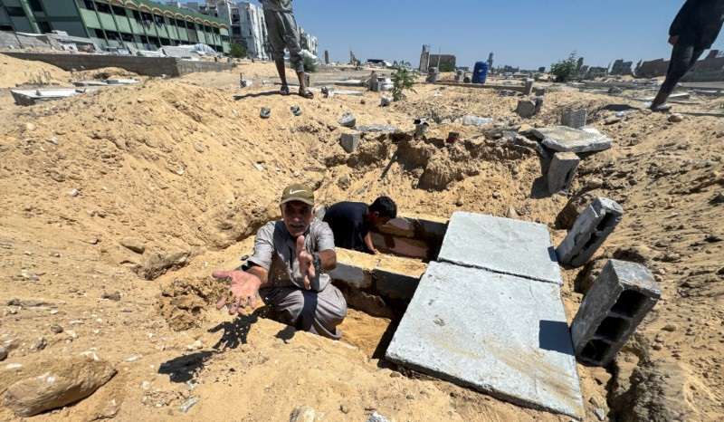 Palestinians prepare graves in a cemetery as death toll surpasses 40,000