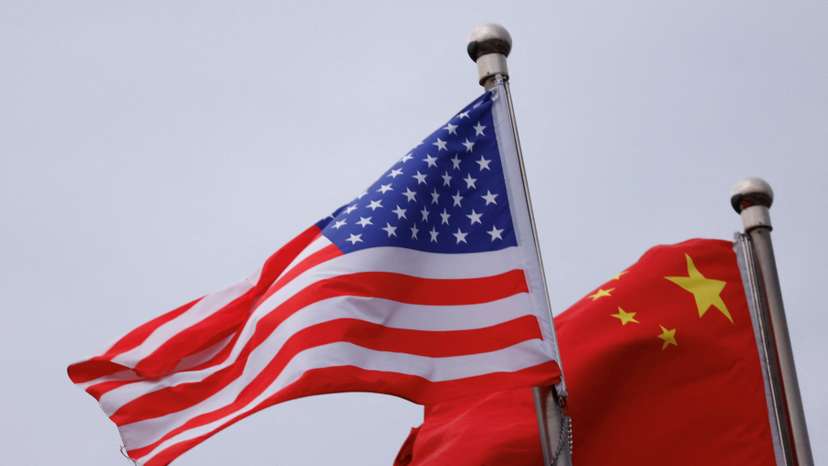 Chinese and U.S. flags flutter outside the building of an American company in Beijing