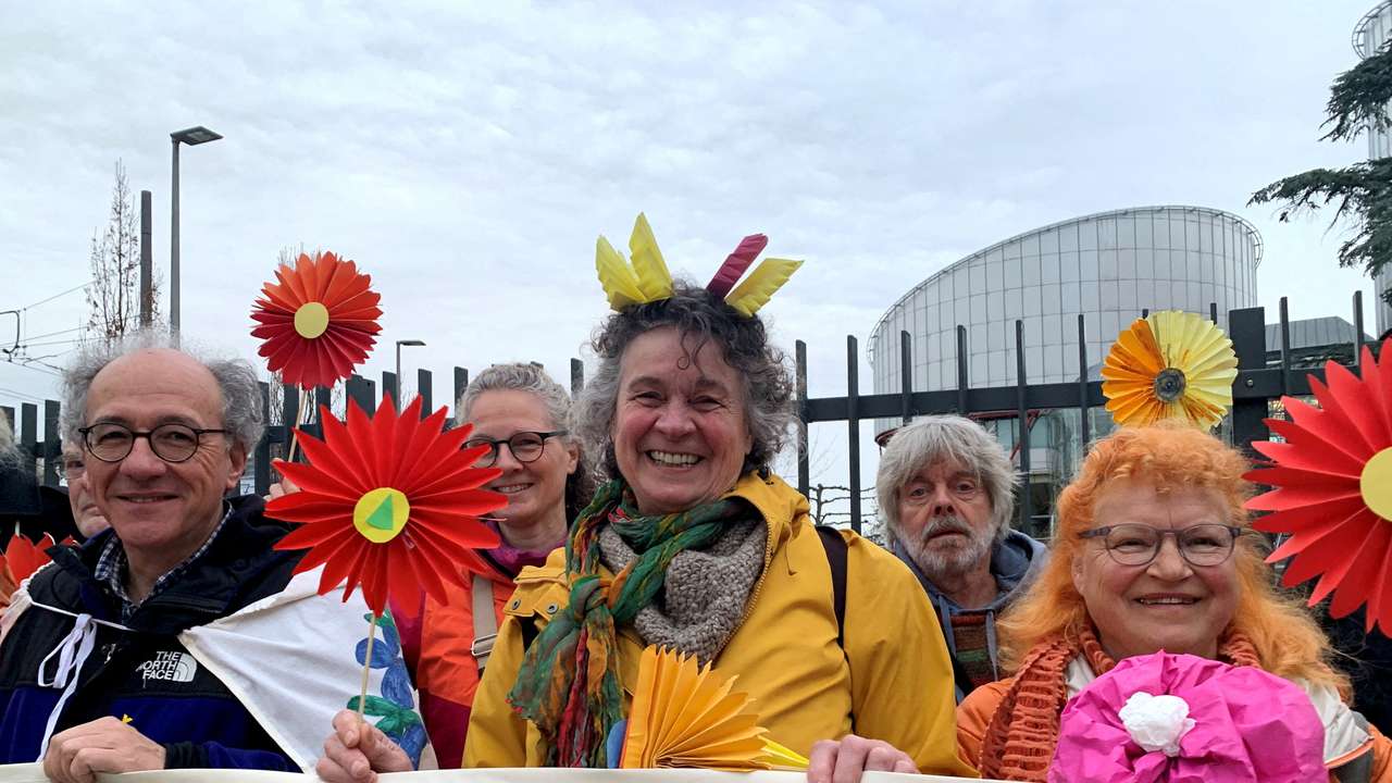 FILE PHOTO: Supporters of the Senior Women for Climate Protection association hold paper flowers and a banner outside the European Court of Human Rights in Strasbourg