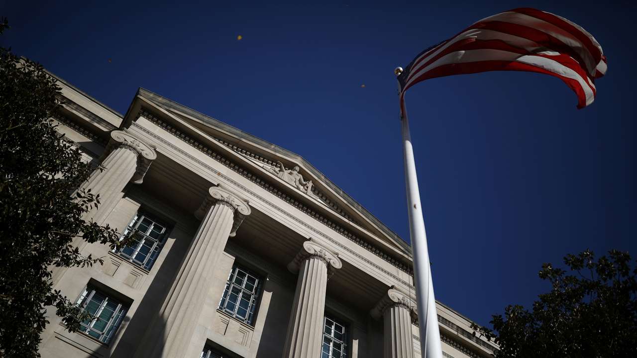 American flag waves outside the U.S. Department of Justice Building in Washington