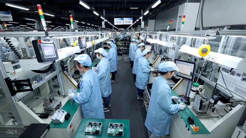 Workers work on a production line manufacturing smart automotive central control navigation products at a factory in Suqian