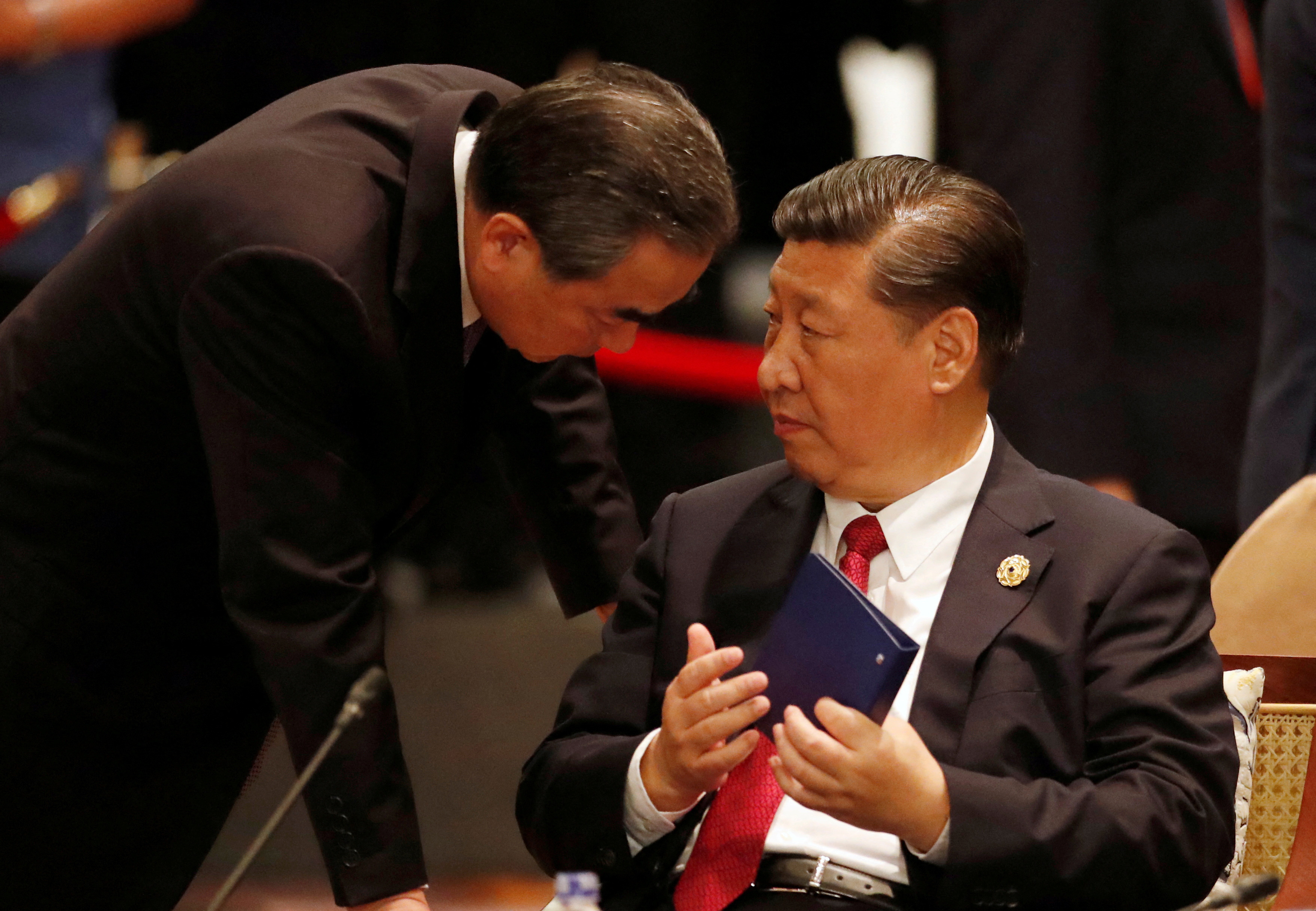 FILE PHOTO: China's President Xi Jinping speaks to Foreign Minister Wang Yi during the APEC-ASEAN dialogue in Danang, Vietnam