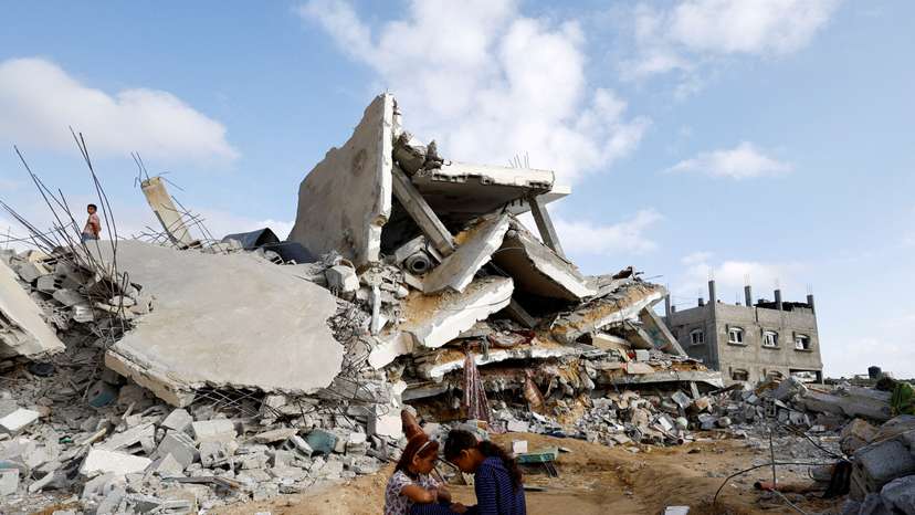 FILE PHOTO: Palestinian children sit next to the site of an Israeli strike on a house, in Rafah
