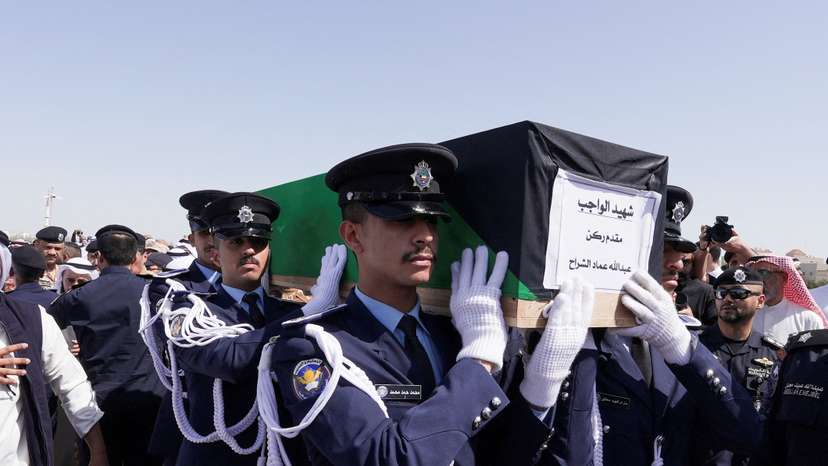 Guards of Honour carry the coffin of one of two police officers, who were killed while performing their duties, during their funeral procession at a graveyard in Kuwait City