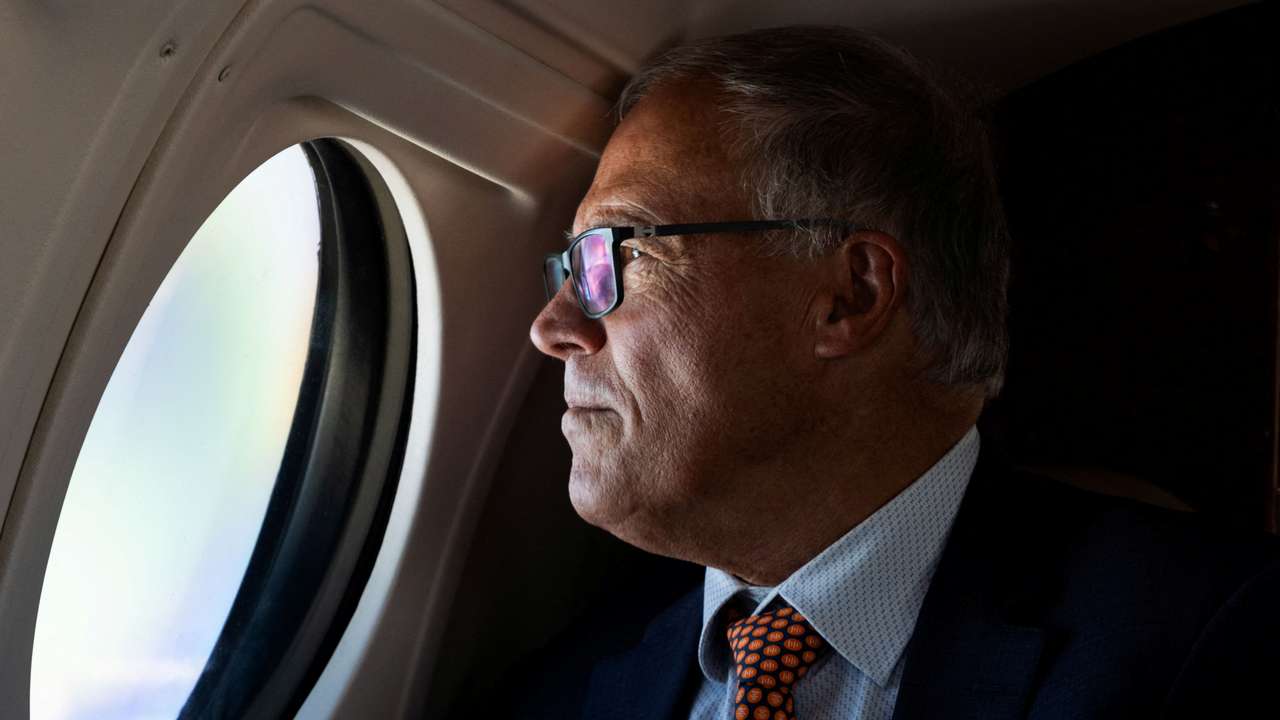 Washington Governor Jay Inslee looks out the window of a Washington State Patrol plane while traveling across the state