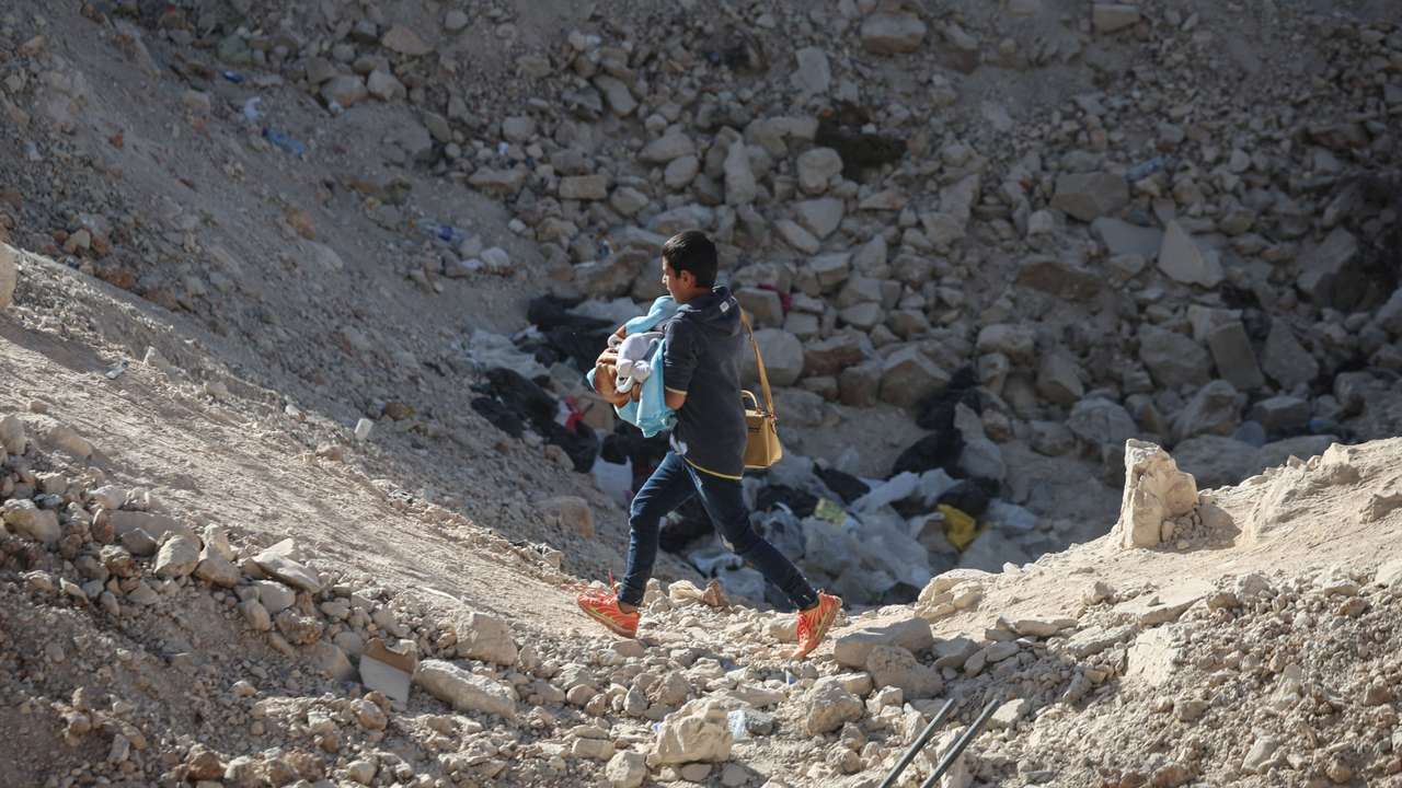 People cross from Lebanon into Syria on foot at the Masnaa border crossing,after Israeli strikes earlier this month