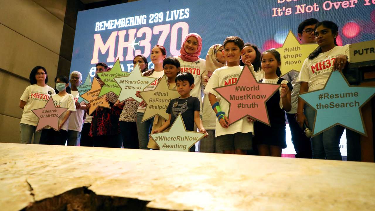 FILE PHOTO: Family members of the victims pose for a group picture with a debris of the missing Malaysia Airlines flight MH370 during its sixth annual remembrance event in Putrajaya