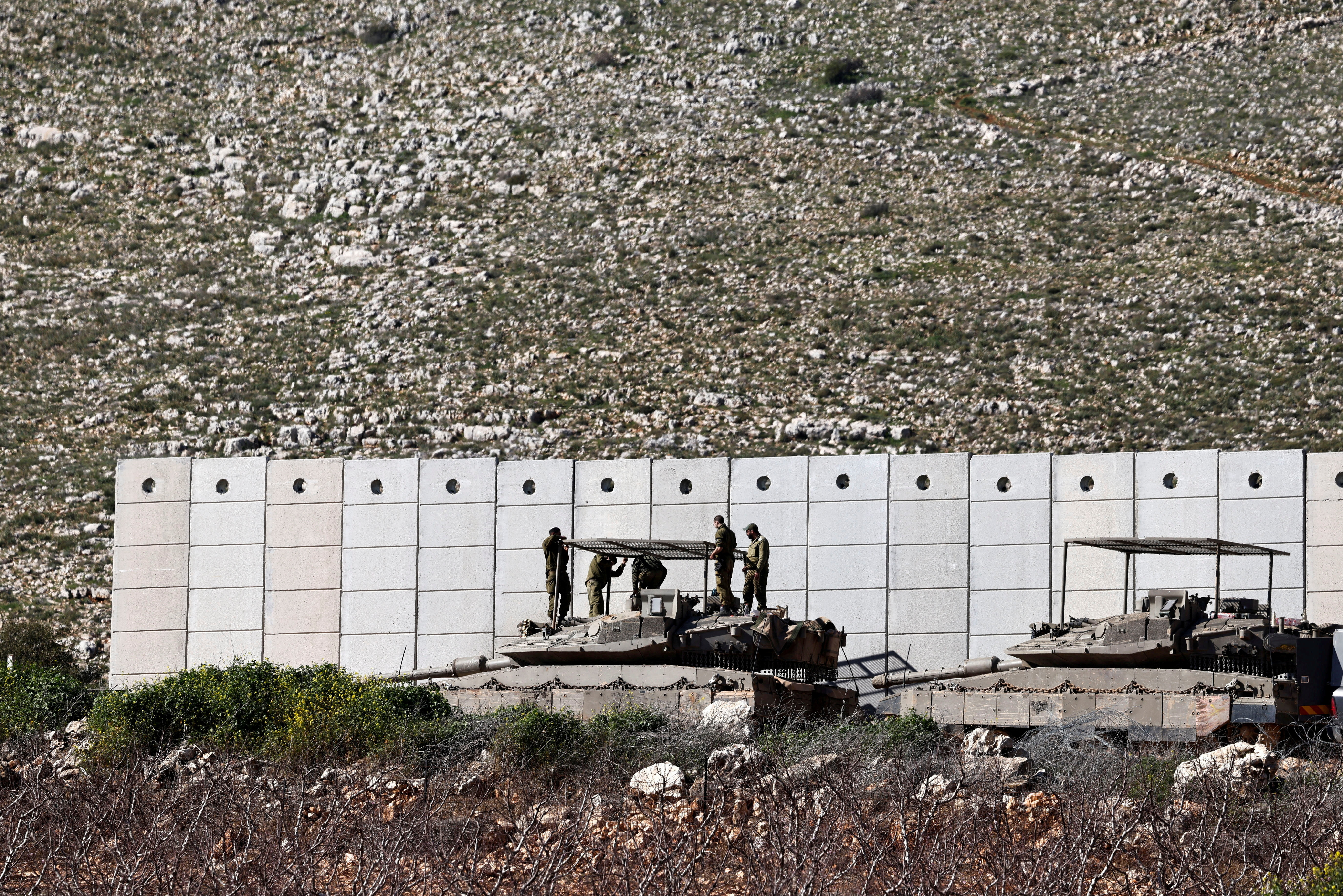 FILE PHOTO: Israeli soldiers work on their tank on the Israeli side of the Israel-Lebanon border