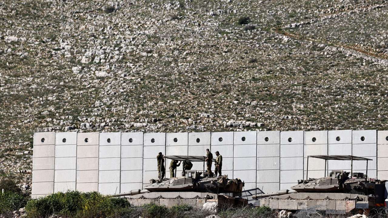 FILE PHOTO: Israeli soldiers work on their tank on the Israeli side of the Israel-Lebanon border