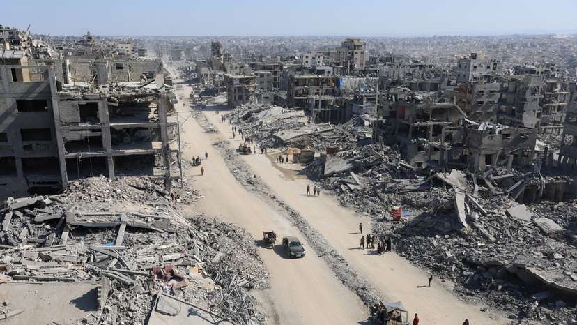 Palestinians walk past the rubble of destroyed buildings, in Gaza City