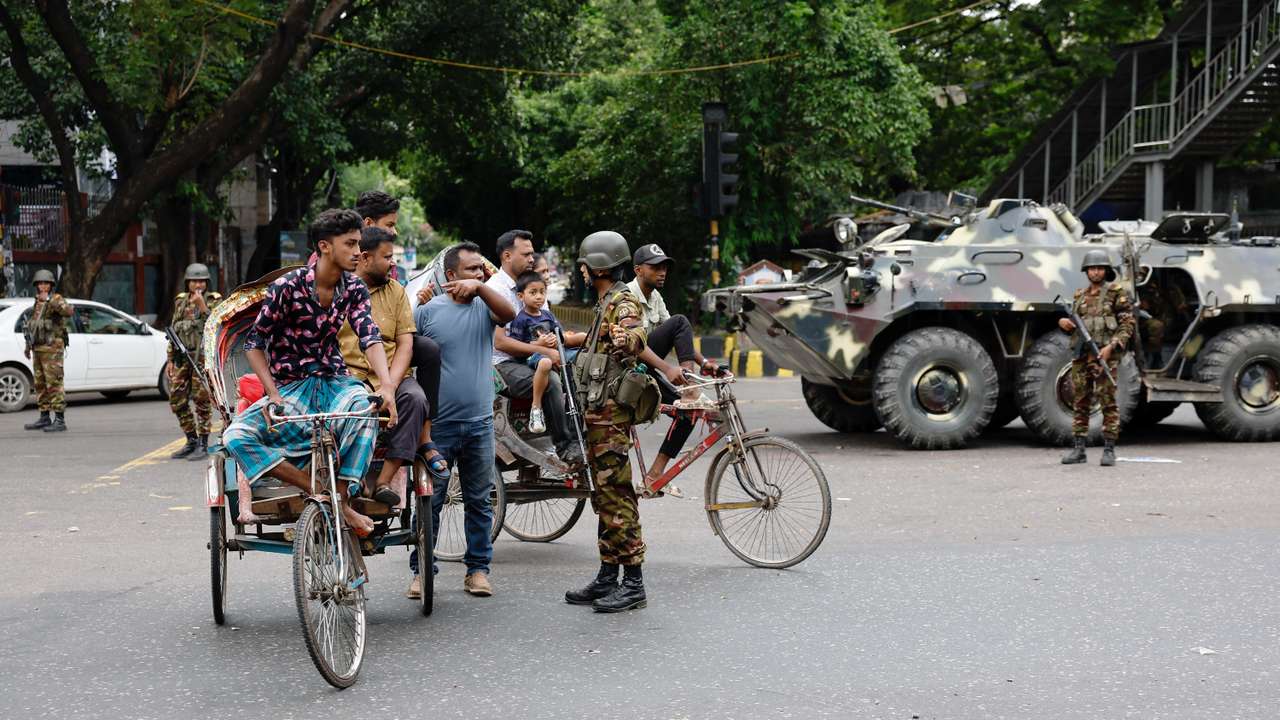 A member of the Bangladesh Army speaks with commuters on the second day of curfew, in Dhaka