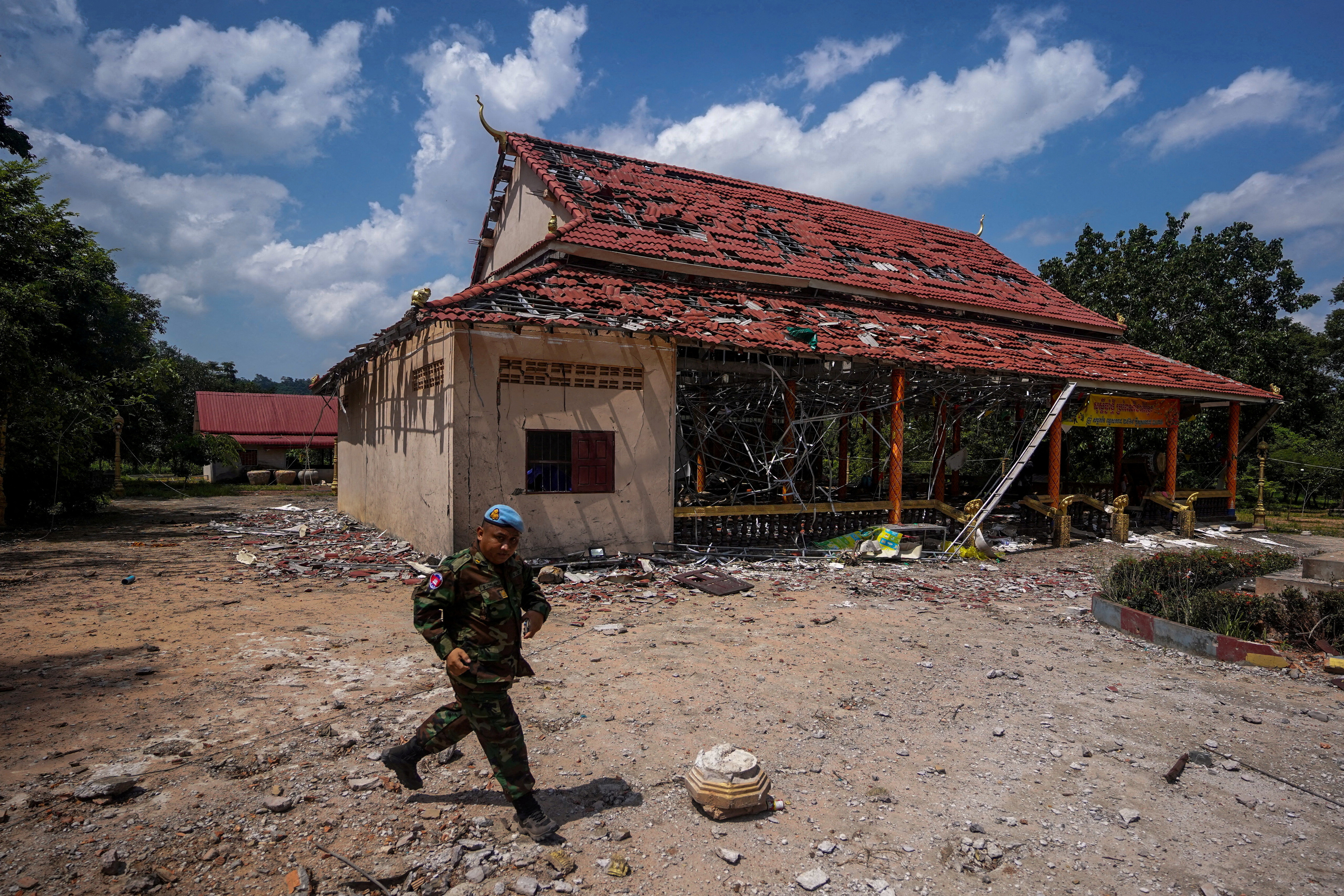 FILE PHOTO: A Cambodian soldier walks past a damaged building during a visit of delegation of foreign diplomats to inspect a damaged area along the Thailand-Cambodia's border