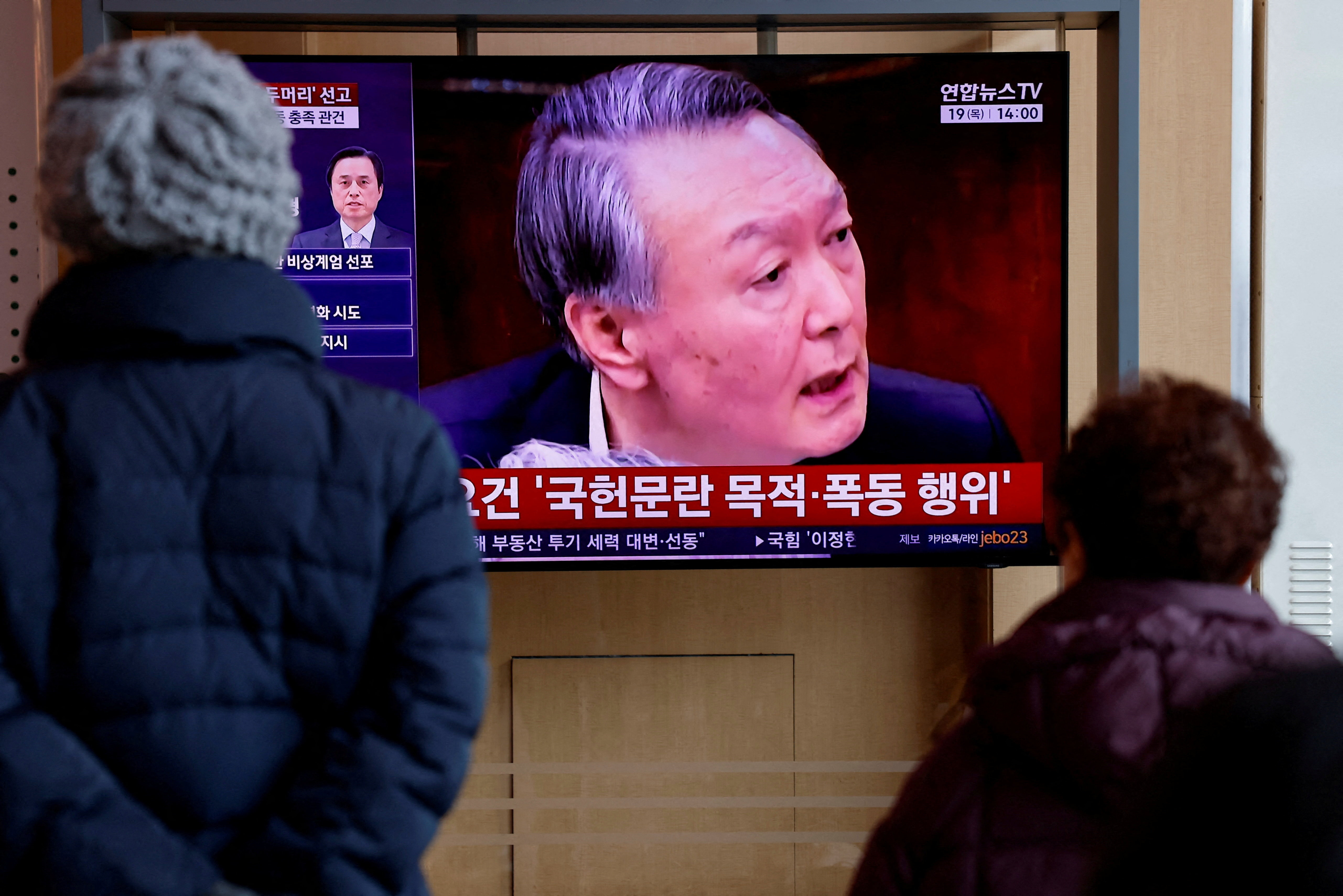 People watch a news report on the sentencing trial of South Korean former president Yoon Suk Yeol's insurrection case in Seoul