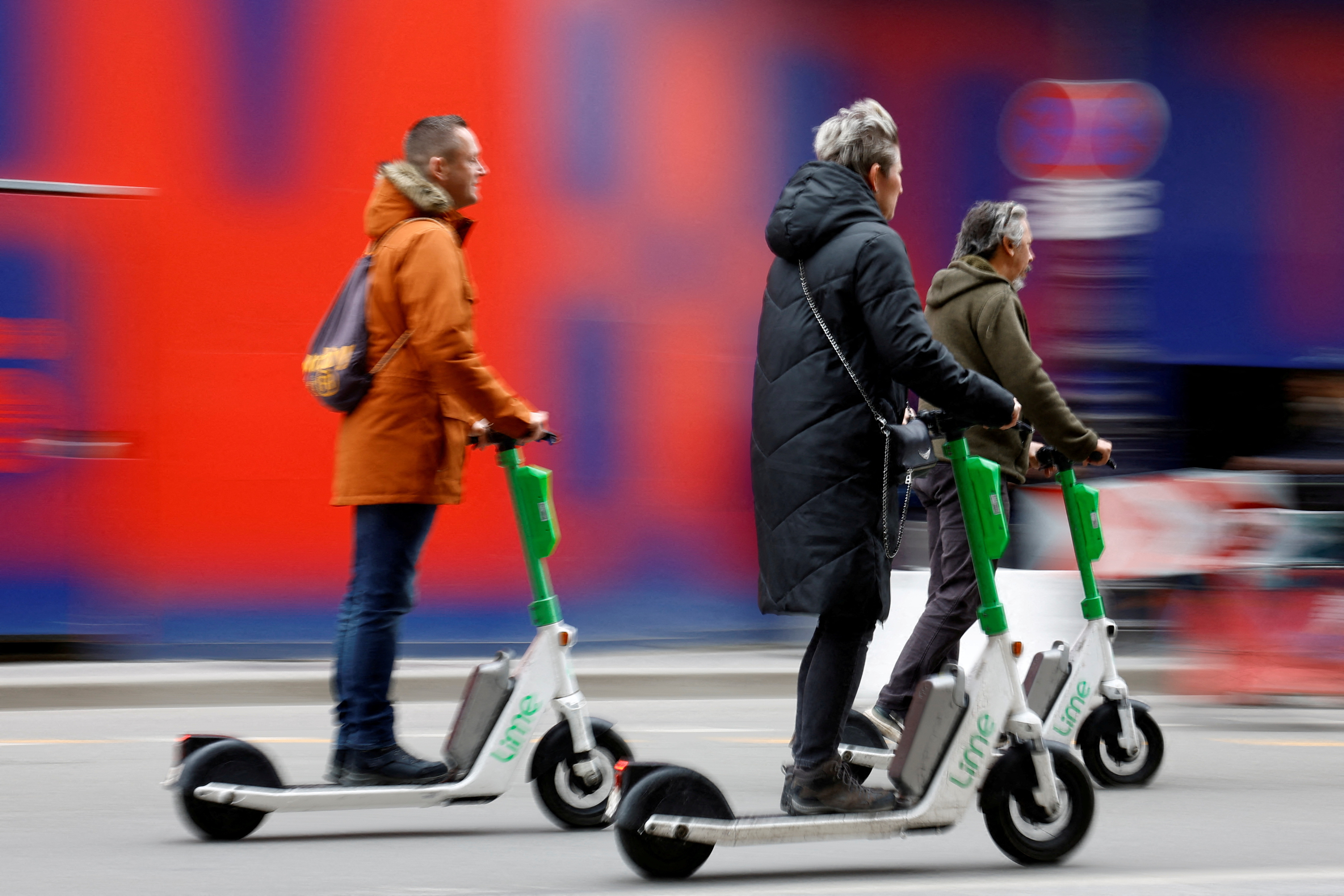 FILE PHOTO: People ride electric scooters on the eve of a public vote to ban or not rental electric scooters in Paris