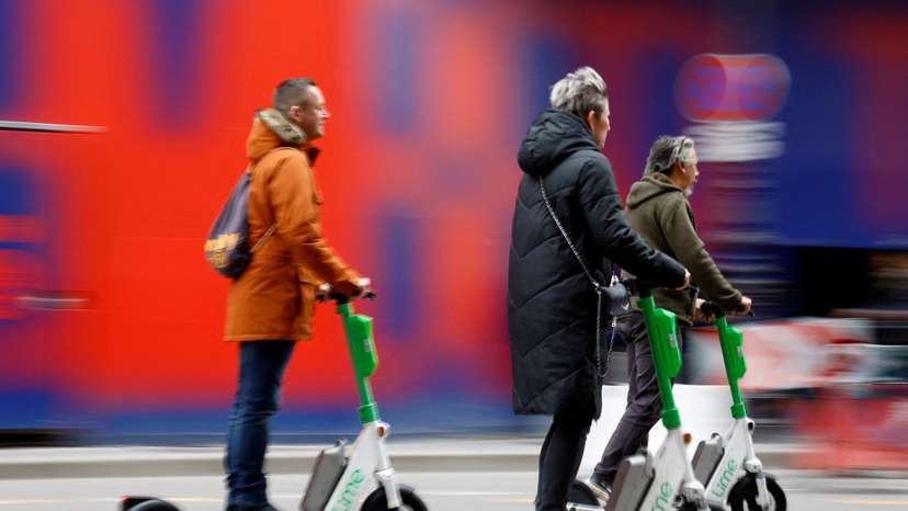 FILE PHOTO: People ride electric scooters on the eve of a public vote to ban or not rental electric scooters in Paris