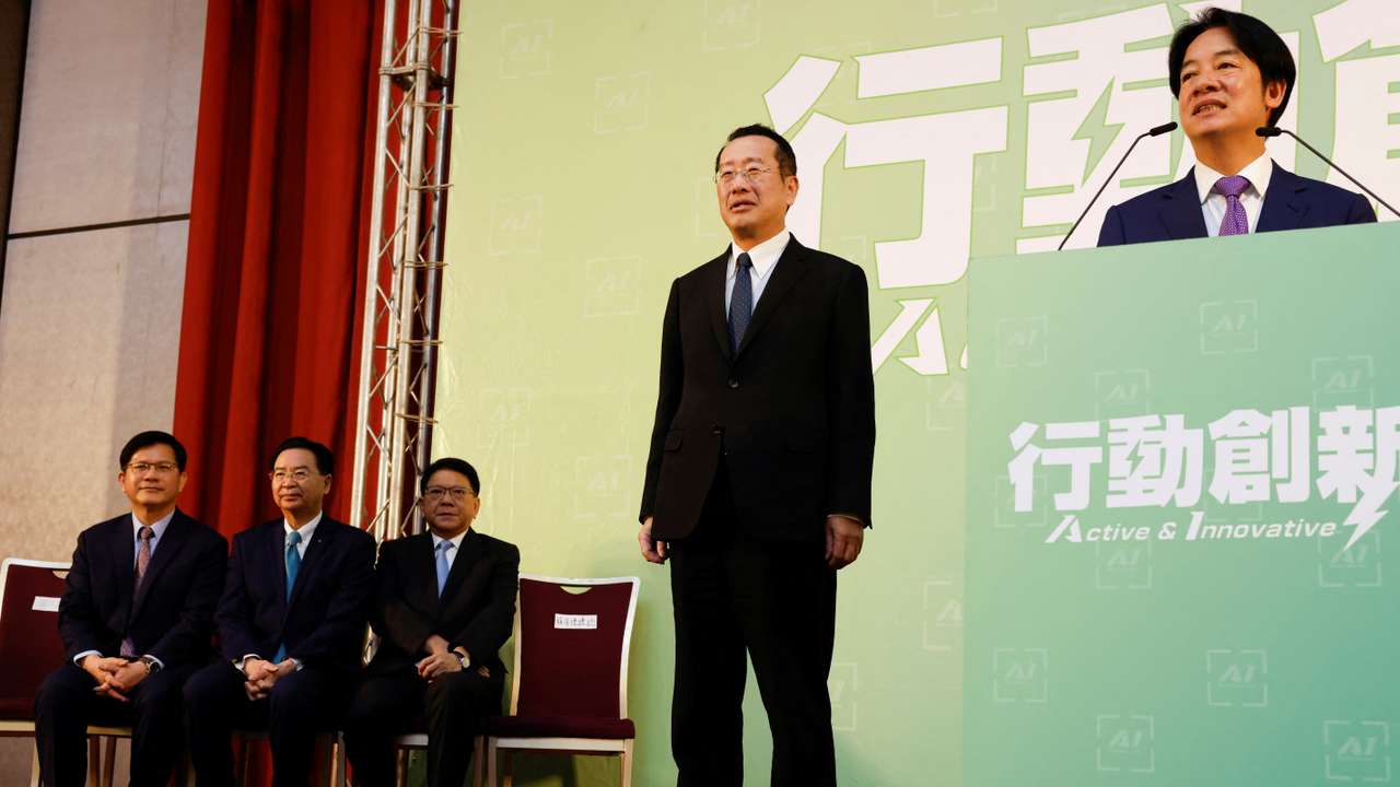 Incoming Defence Minister Wellington Koo stands next to Taiwan President-elect Lai Ching-te while he speaks during a press conference, in Taipei