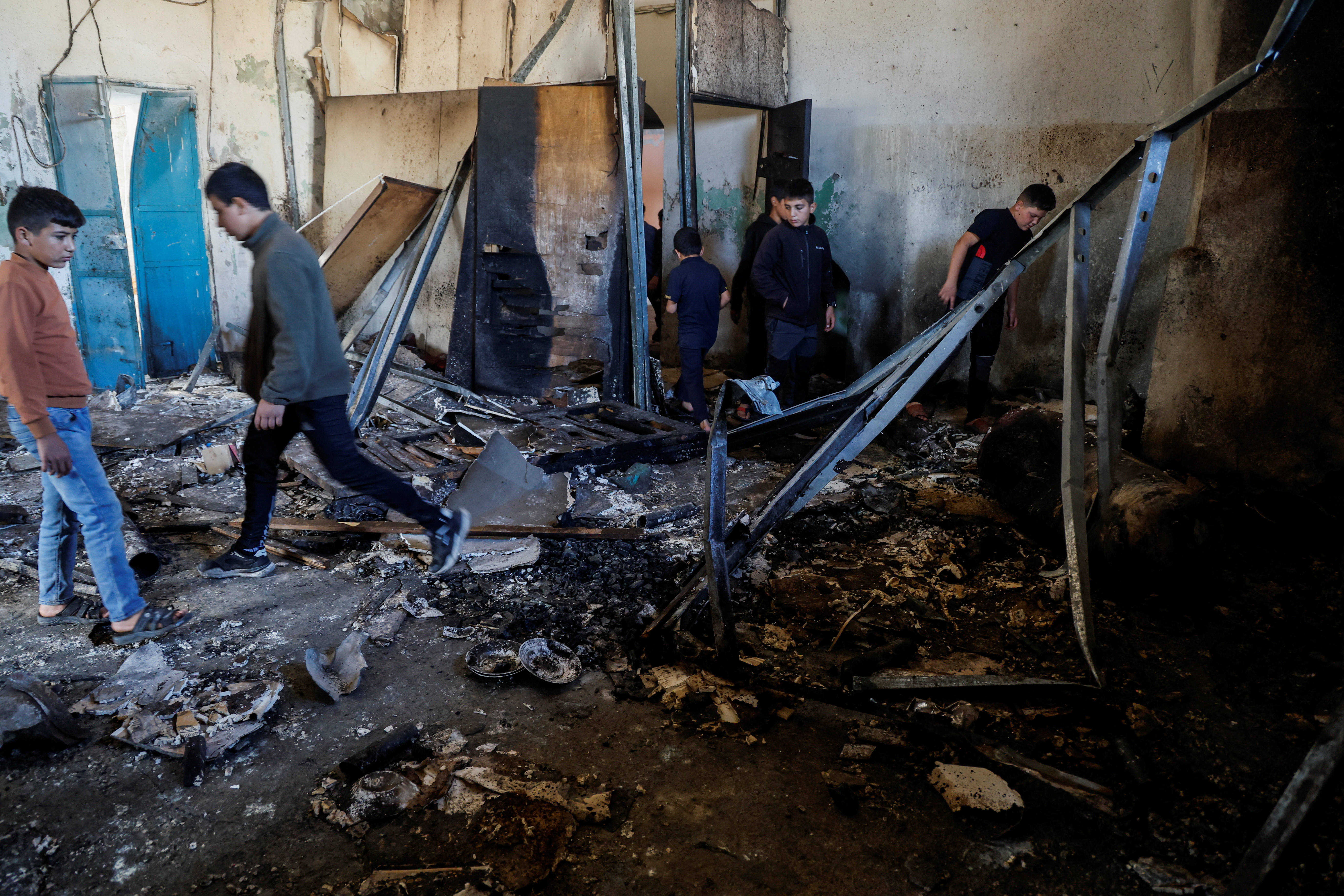 People inspect a building that was blown up during an Israeli raid in Qabatiya, near Jenin