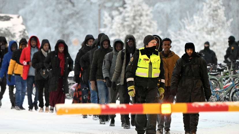 FILE PHOTO: Finnish Border Guards escort the migrants at the international border crossing at Salla