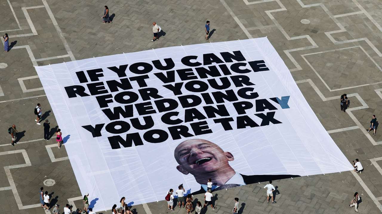 A large banner against Amazon founder Jeff Bezos lies on the ground in St. Mark's Square