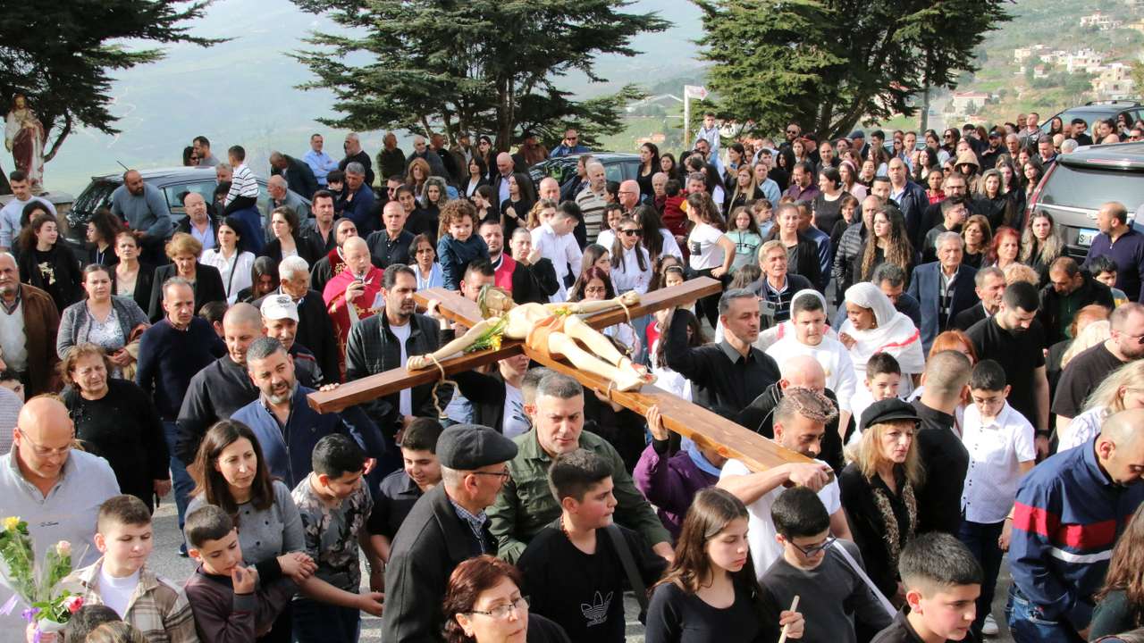 Christian worshippers take part in the Good Friday procession as they carry a cross with a Jesus Christ statue, in the town of Klayaa