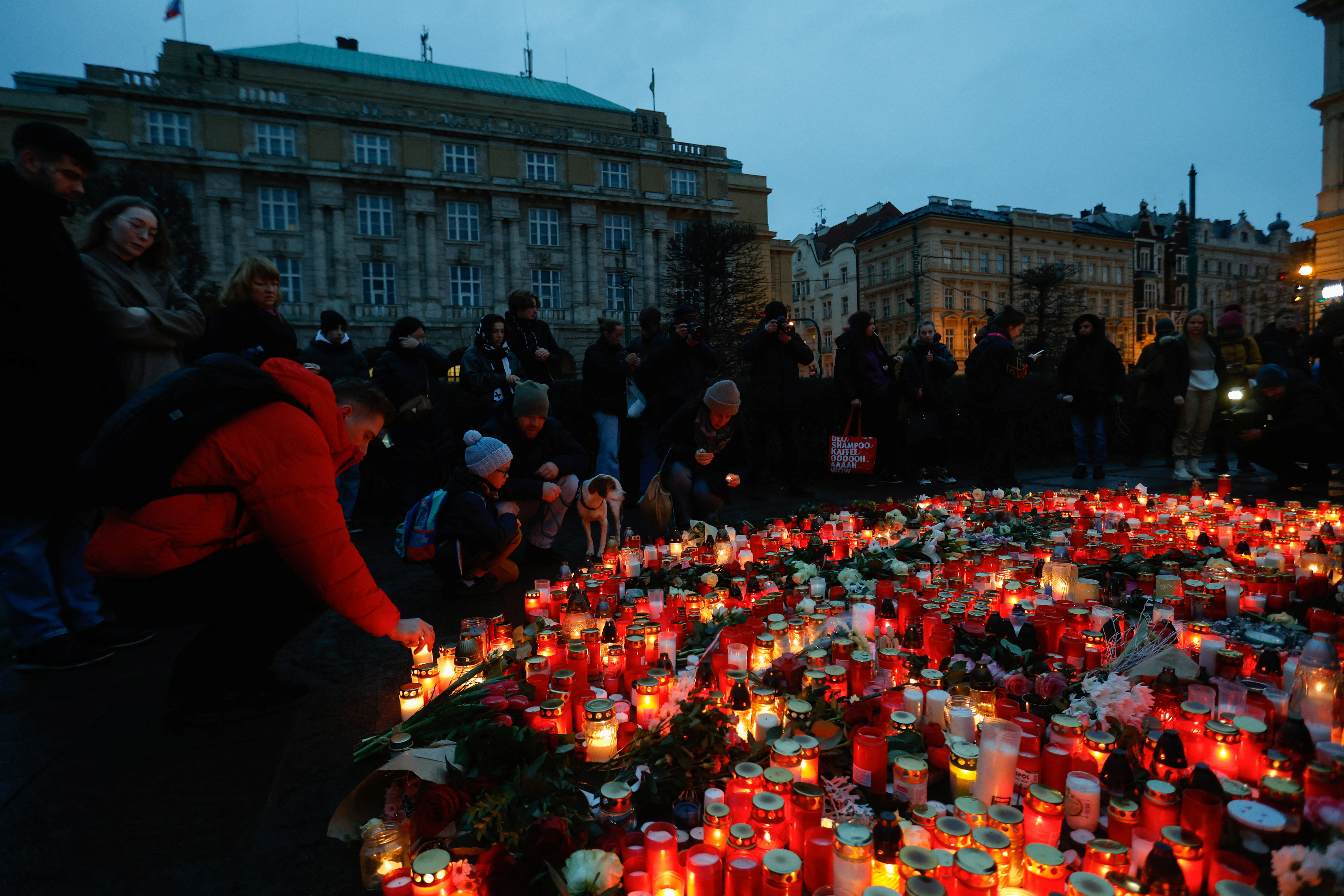People hold a vigil to honour victims of Prague shooting