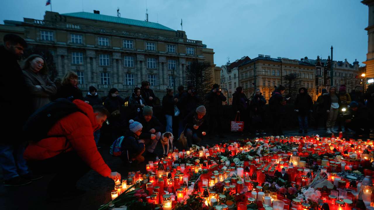 People hold a vigil to honour victims of Prague shooting