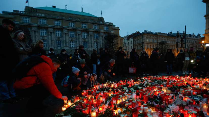 People hold a vigil to honour victims of Prague shooting