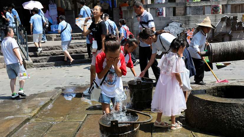 A child rinses her face with water amid a red alert for heat in Chongqing