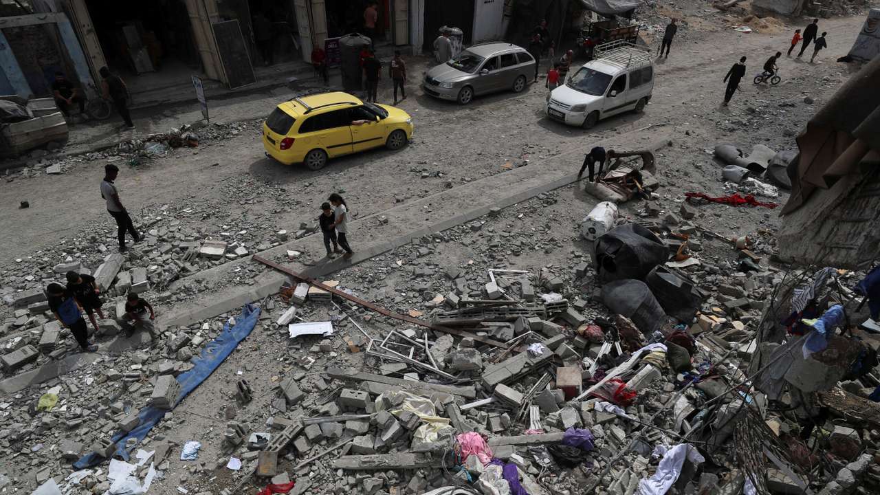 Palestinians inspect the site of an Israeli strike on a house, in Gaza City