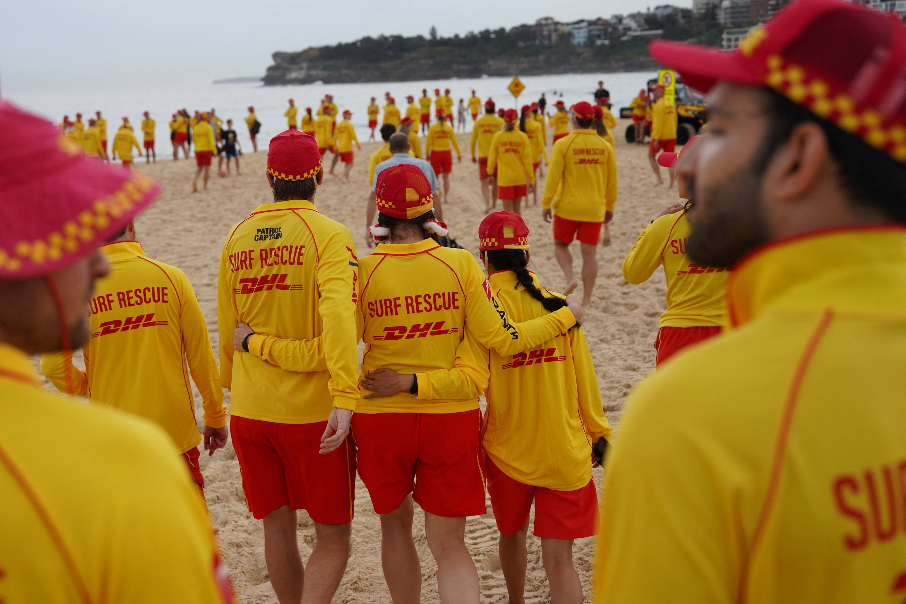 People lay flowers and pay tribute to honour the victims of a mass shooting in Sydney