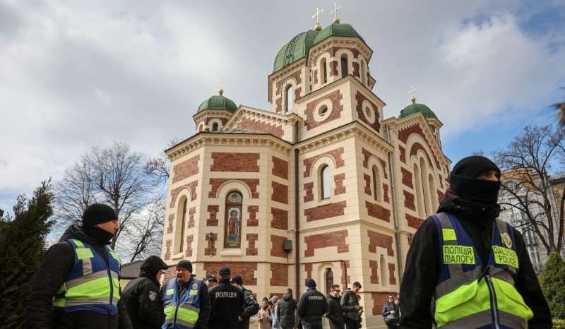 Ukrainian police officers stand next to St. George's Cathedral of the Ukrainian Orthodox Church, accused of being linked to Moscow in Lviv