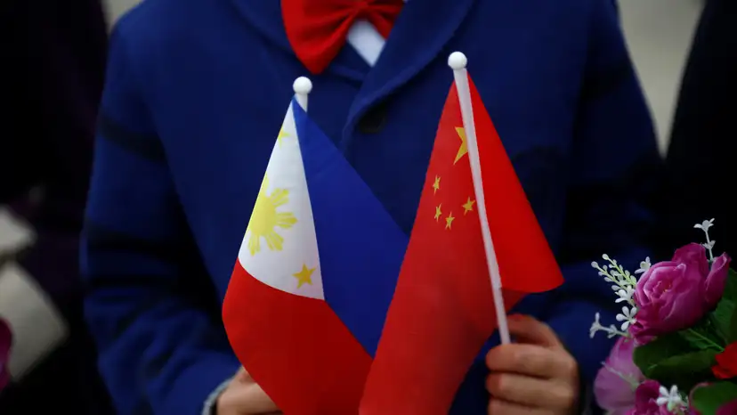 FILE PHOTO: Children hold plastic flowers, national flags of China and the Philippines before President of the Philippines Rodrigo Duterte and China's President Xi Jinping attend a welcoming ceremony at the Great Hall of the People in Beijing