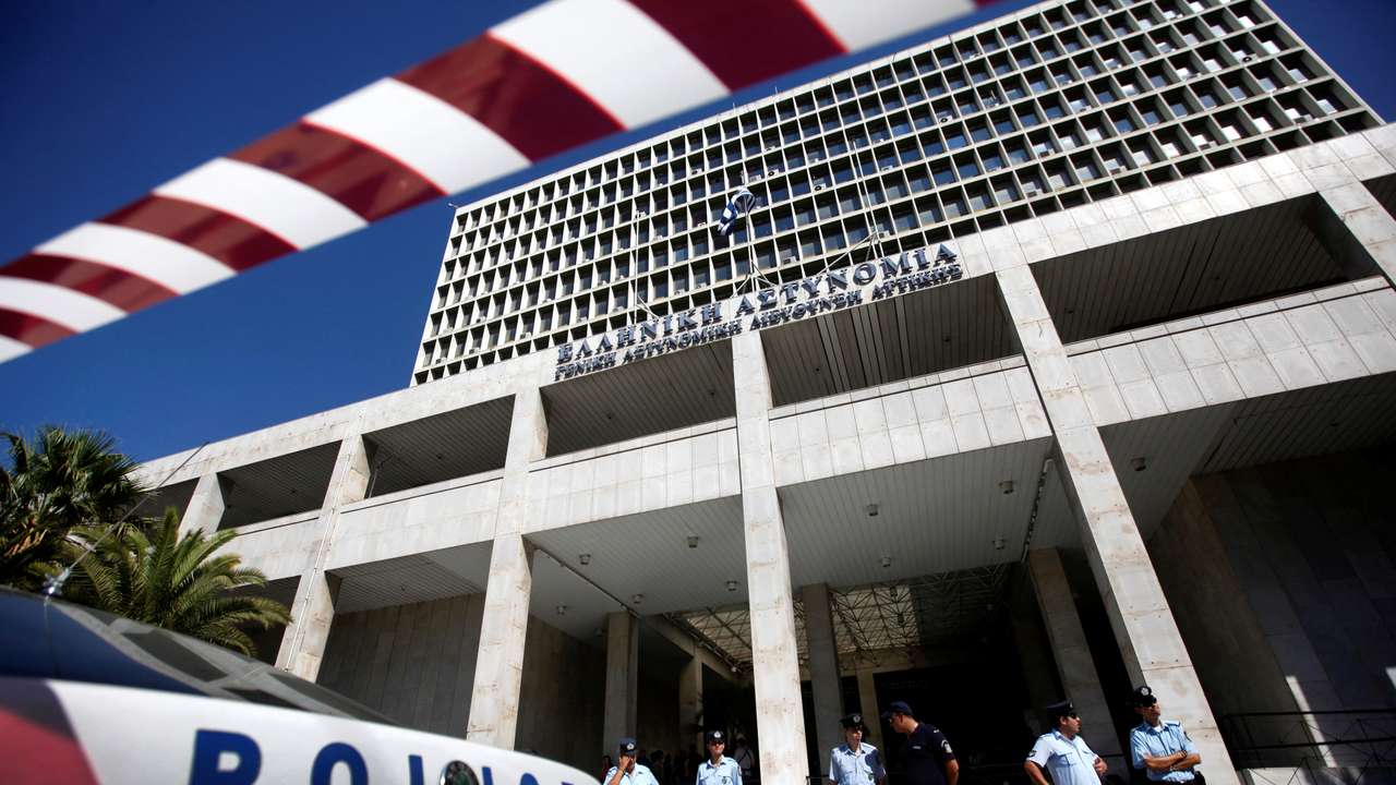 FILE PHOTO: Police officers stand guard outside the Greek police headquarters in Athens