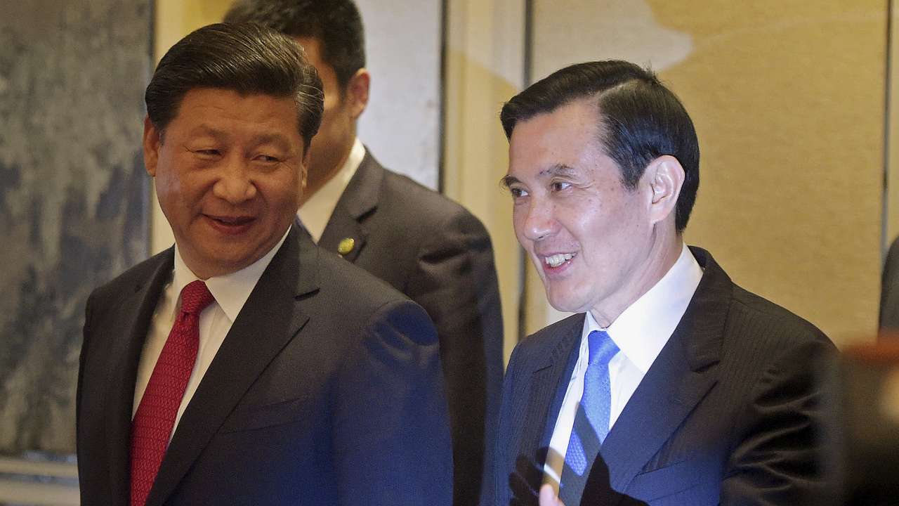 FILE PHOTO: Chinese President Xi Jinping and then Taiwanese President Ma Ying-jeou smile as they enter the room at the Shangri-la Hotel where they are to meet, in Singapore