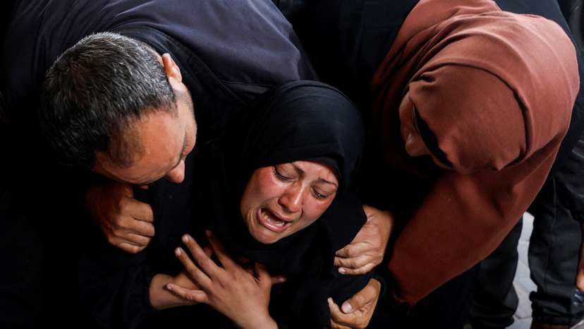 Mourners react next to the bodies of Palestinians killed in Israeli strikes, in Rafah
