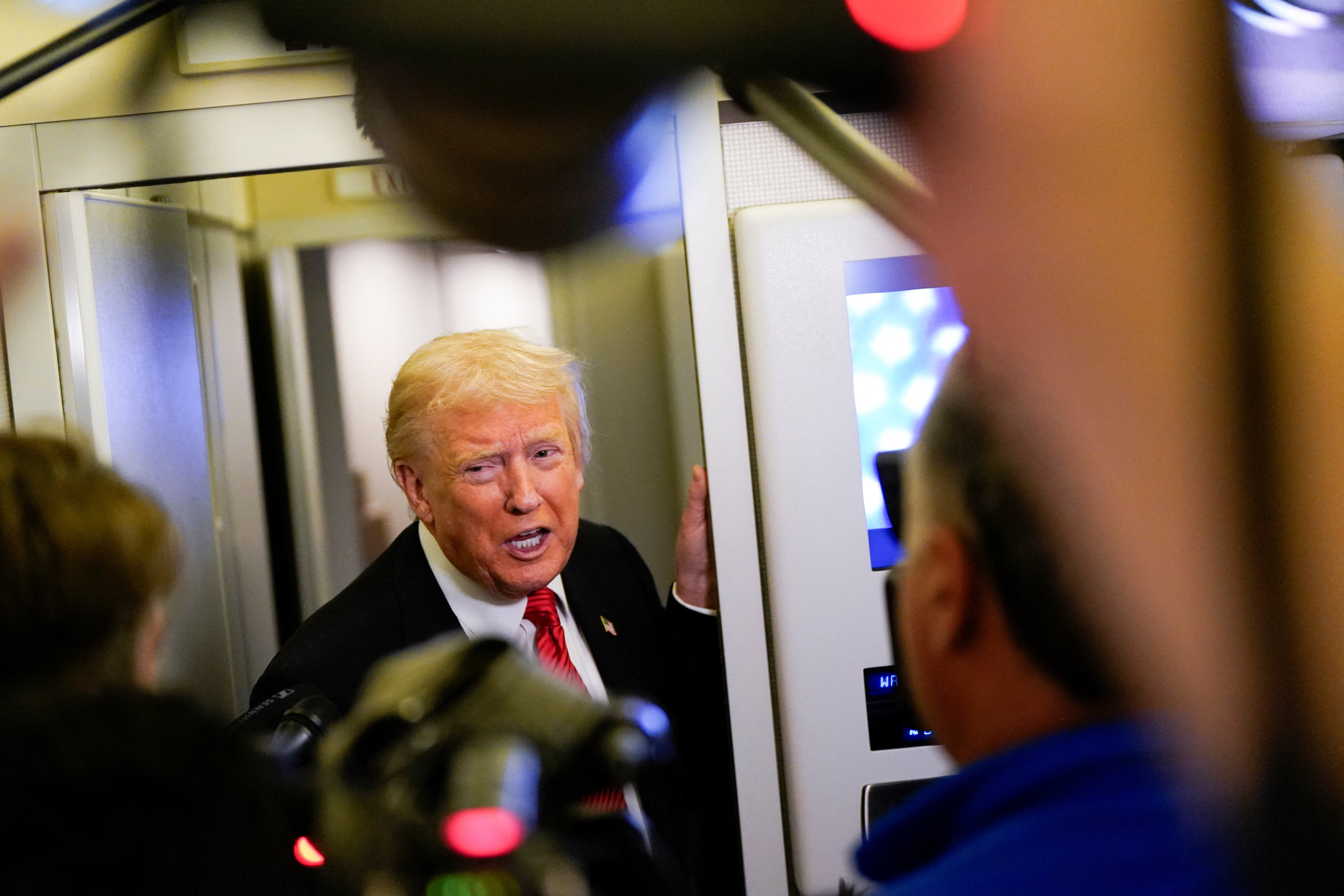 U.S. President Trump speaks to members of the media on board Air Force One en route to Joint Base Andrews