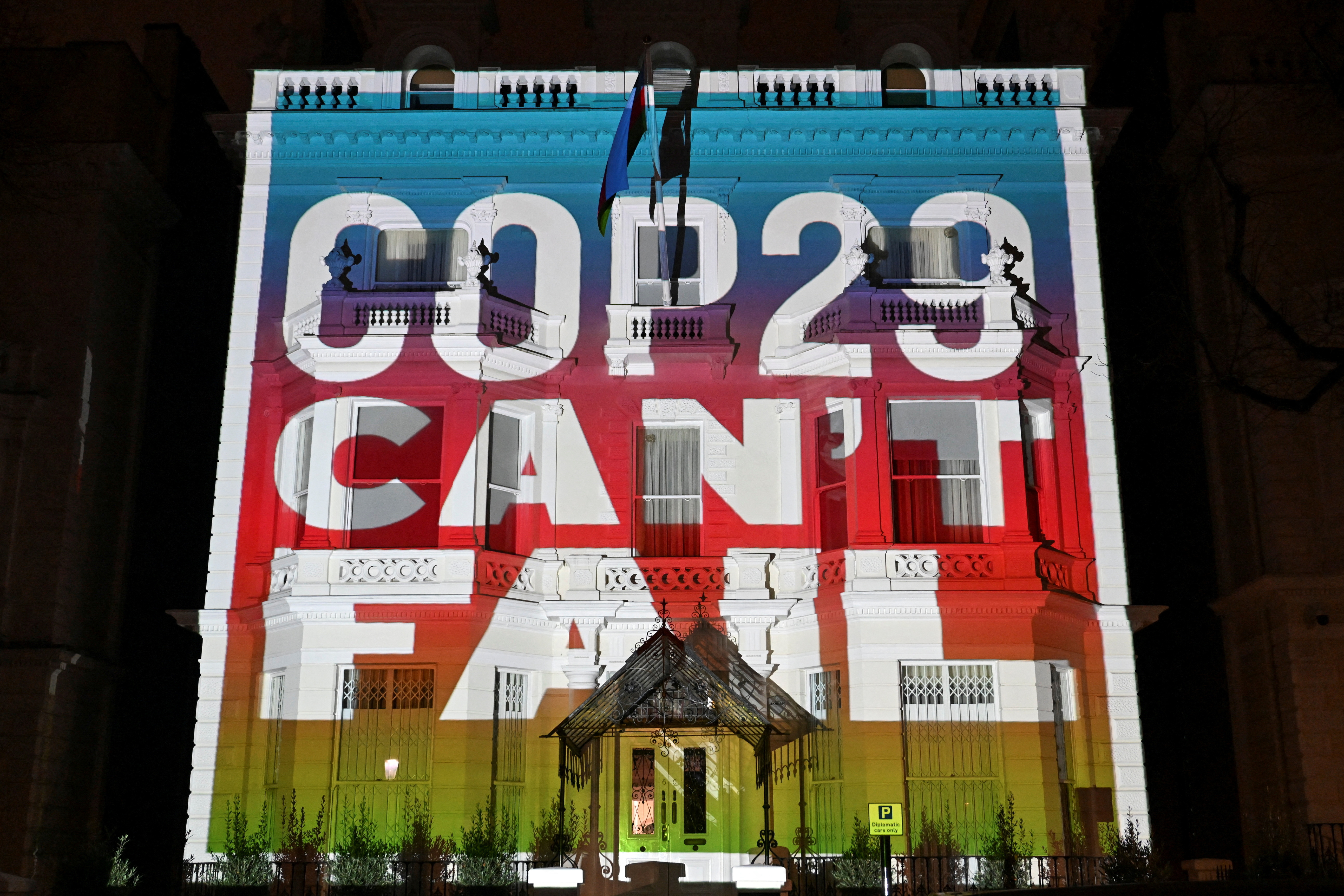 Climate activists project a message onto the Embassy of Azerbaijan ahead of COP29 climate talks, in London