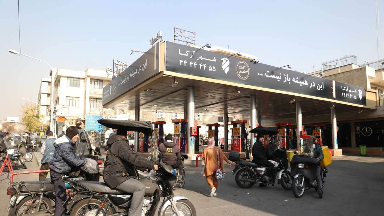 People wait at a gas station during gas station disruption in Tehran