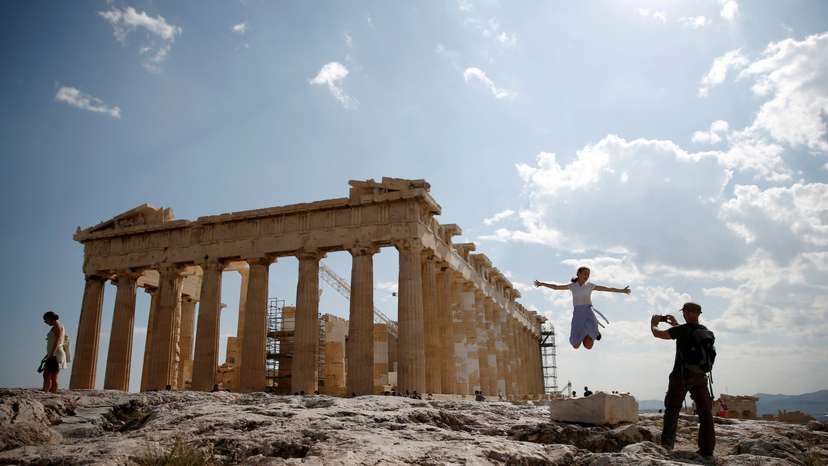 FILE PHOTO: Tourists take a picture in front of the temple of the Parthenon atop the Acropolis in Athens
